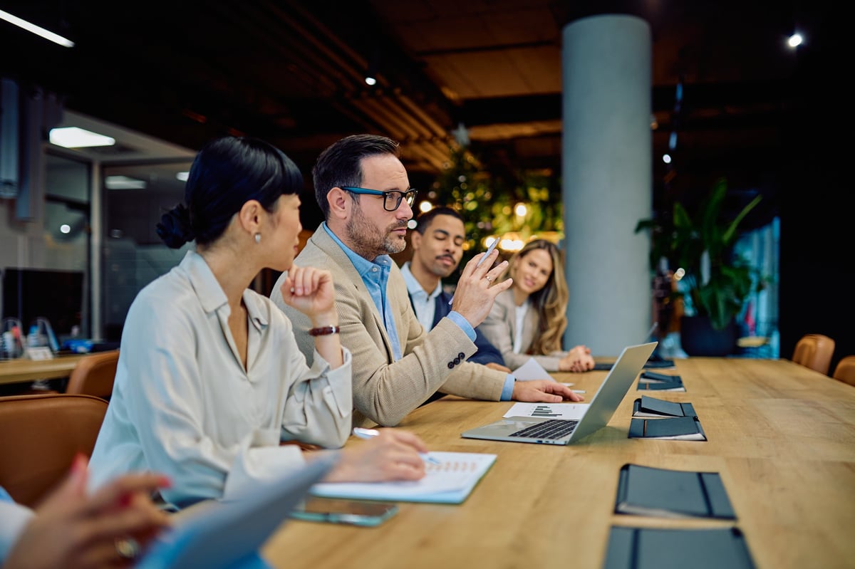 Business professionals engaging in a meeting, discussing strategy and ideas, reflecting teamwork and communication in the office